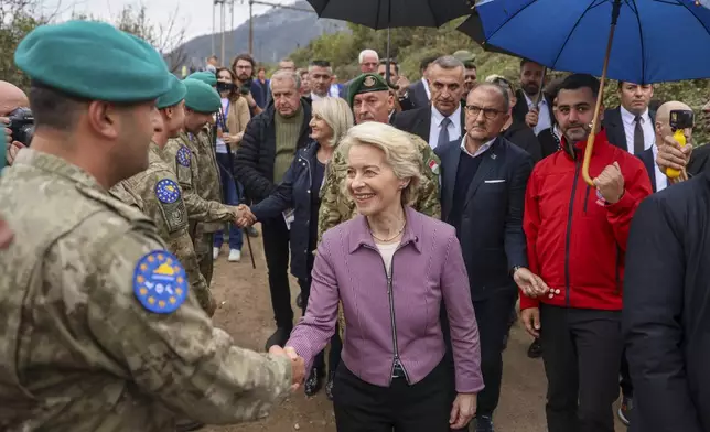 European Commission president Ursula von der Leyen shakes hands with an Effort soldier during her visit to the area that was recently hit by floods and landslides, in Jablanica, Bosnia, Thursday, Oct. 24, 2024.(AP Photo/Armin Durgut)