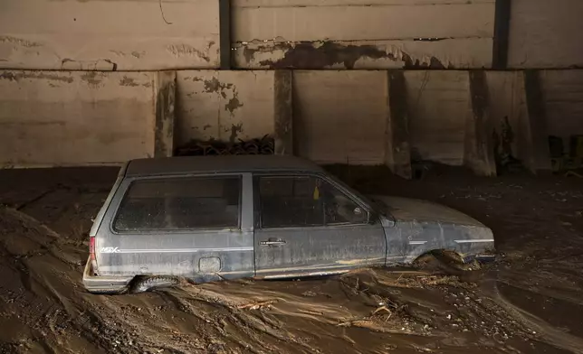 A car is submerged in mud following a flooding in Buturovic Polje, Bosnia, Sunday, Oct. 6, 2024. (AP Photo/Armin Durgut)