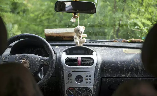 A toy hangs on the rear view mirror in a car destroyed after flooding in the village of Donja Jablanica, Bosnia, Saturday, Oct. 5, 2024. (AP Photo/Armin Durgut)