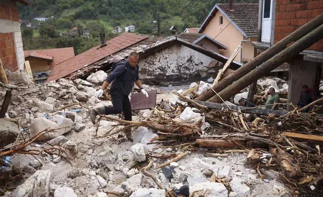 People inspect a damaged house after floods and landslides in the village of Donja Jablanica, Bosnia, Saturday, Oct. 5, 2024. (AP Photo/Armin Durgut)