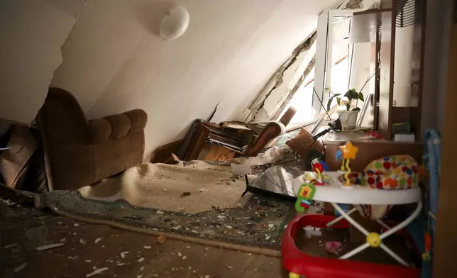 A living room is seen inside a house where a roof collapsed following torrential rain and flooding in Buturovic Polje, Bosnia, Sunday, Oct. 6, 2024. (AP Photo/Armin Durgut)