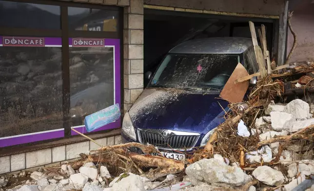 A damaged car is seen after flood hit the village of Donja Jablanica, Bosnia, Saturday, Oct. 5, 2024. (AP Photo/Armin Durgut)