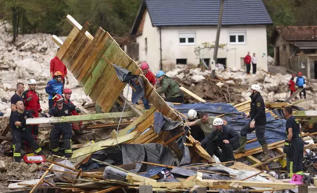 Rescuers search for missing people after floods and landslides in the village of Donja Jablanica, Bosnia, Saturday, Oct. 5, 2024. (AP Photo/Armin Durgut)