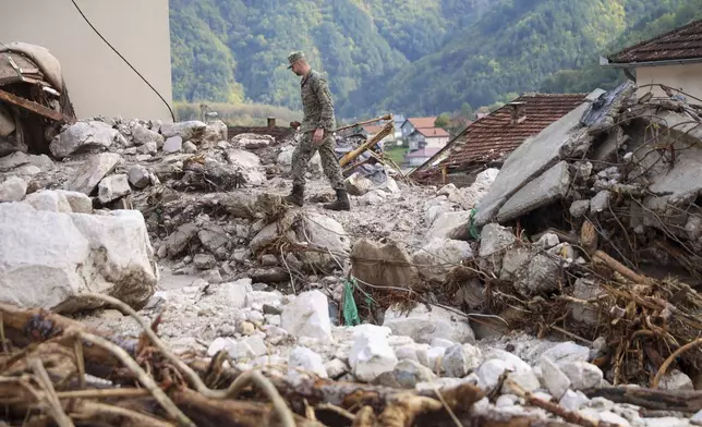 A Bosnian soldier inspects a damaged house after floods and landslides in the village of Donja Jablanica, Bosnia, Saturday, Oct. 5, 2024. (AP Photo/Armin Durgut)