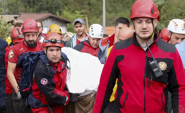 Members of the mountain rescue service carry a body of a person killed by a landslide in the flooded village of Donja Jablanica, Bosnia, Saturday, Oct. 5, 2024. (AP Photo/Armin Durgut)