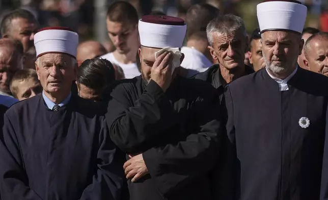 Imams and mourners attend the collective funeral for 19 victims of a landslide caused by recent floods in Jablanica, Bosnia, Tuesday, Oct. 15, 2024. (AP Photo/Armin Durgut)