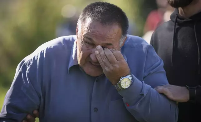 A mourner weeps before the funeral of 19 victims of recent floods in Jablanica, Bosnia, Tuesday, Oct. 15, 2024. (AP Photo/Armin Durgut)