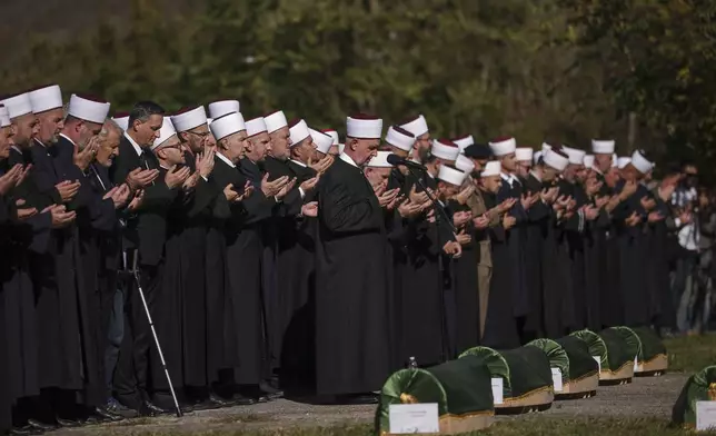 Imams and mourners attend the collective funeral for 19 victims of a landslide caused by recent floods in Jablanica, Bosnia, Tuesday, Oct. 15, 2024. (AP Photo/Armin Durgut)