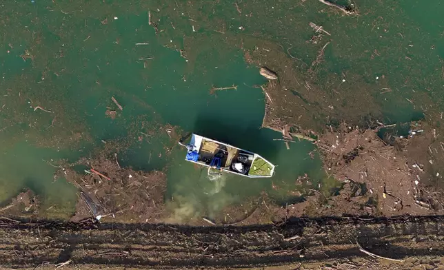 Aerial view of Ibro Mesic collecting plastic waste from his boat after devastating floods and landslides put tons of waste in Jablanicko lake near Ostrozac, Bosnia, Sunday, Oct. 20, 2024. (AP Photo/Armin Durgut)