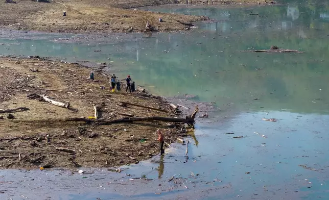 Aerial view of volunteers collecting plastic waste from the shore after devastating floods and landslides put tons of waste in Jablanicko lake near Ostrozac, Bosnia, Sunday, Oct. 20, 2024. (AP Photo/Armin Durgut)