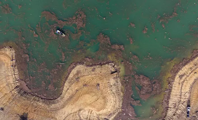 Aerial view of Ibro Mesic collecting plastic waste from his boat after devastating floods and landslides put tons of waste in Jablanicko lake near Ostrozac, Bosnia, Sunday, Oct. 20, 2024. (AP Photo/Armin Durgut)