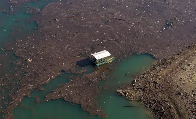 An aerial view of a boat carrying bags of trash after devastating floods and landslides put tons of waste in Jablanicko lake near Ostrozac, Bosnia, Sunday, Oct. 20, 2024. (AP Photo/Armin Durgut)