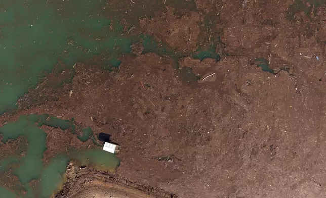 Aerial view of a boat carrying bags of trash after devastating floods and landslides put tons of waste in Jablanicko lake near Ostrozac, Bosnia, Sunday, Oct. 20, 2024. (AP Photo/Armin Durgut)