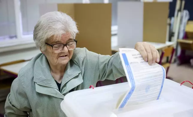 A woman casts her vote for a municipal election at a polling station in Sarajevo, Bosnia, Sunday, Oct. 6, 2024. (AP Photo/Armin Durgut)