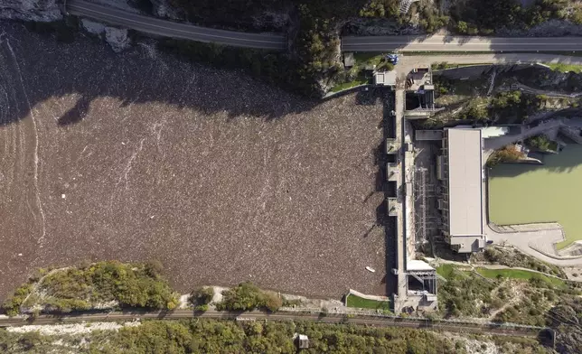 Aerial view of waste stuck at the dam on the Neretva river caused by landslides, torrential rain and flash floods in Grabovica, Bosnia, Sunday, Oct. 13, 2024. (AP Photo/Armin Durgut)