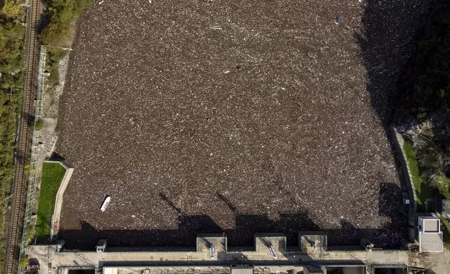 Aerial view of waste stuck at the dam on the Neretva river caused by landslides, torrential rain and flash floods in Grabovica, Bosnia, Sunday, Oct. 13, 2024. (AP Photo/Armin Durgut)