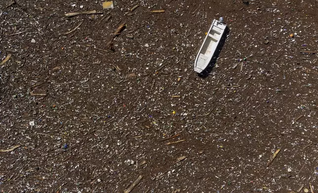 Aerial view of a stranded boat stuck at the dam on the Neretva river caused by landslides, torrential rain and flash floods in Grabovica, Bosnia, Sunday, Oct. 13, 2024. (AP Photo/Armin Durgut)