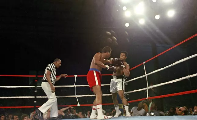 FILE - Challenger Muhammad Ali is hit with a left jab by defending world champion George Foreman during the WBA/WBC championship bout in Kinshasa, Zaire, on Oct. 30, 1974. (AP Photo, File)