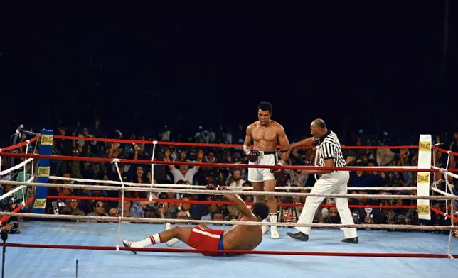 FILE - Muhammad Ali looks down at George Foreman during their bout in Kinshasa, Zaire, Oct. 30, 1974. (AP Photo, File)