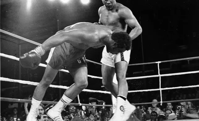 FILE - Challenger Muhammad Ali, right, watches as defending world champion George Foreman goes down to the canvas in the eighth round of their WBA/WBC championship match, on Oct. 30, 1974, in Kinshasa, Zaire. (AP Photo/Richard Drew, File)