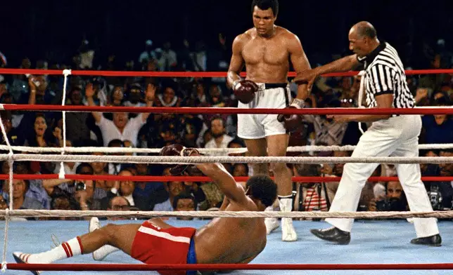 FILE - In this Oct. 30, 1974 file photo, referee Zack Clayton, right, steps in after challenger Muhammad Ali looks on after knocking down defending heavyweight champion George Foreman in the eighth round of their championship bout in Kinshasa, Zaire. (AP Photo/File)