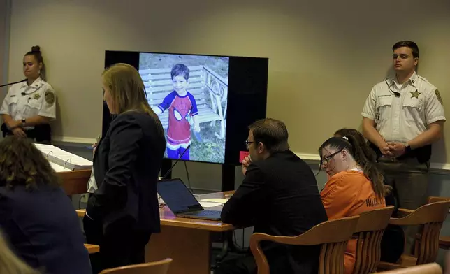 Assistant Attorney General Meghan Hagaman displays a photo of Elijah Lewis at the sentencing hearing for Danielle Dauphinais, seated at Hillsborough County Superior Court South in Nashua, N.H., on Friday, Oct. 25, 2024. (David Lane/Union Leader via AP, Pool)