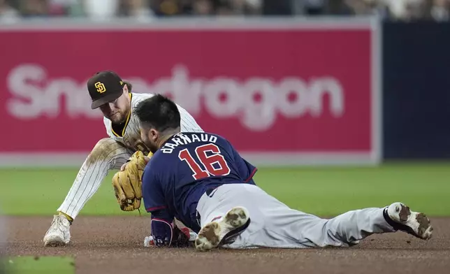 Atlanta Braves' Travis d'Arnaud (16) slides into second base with a double before the tag attempt from San Diego Padres second baseman Jake Cronenworth during the fourth inning in Game 1 of an NL Wild Card Series baseball game Tuesday, Oct. 1, 2024, in San Diego. (AP Photo/Gregory Bull)