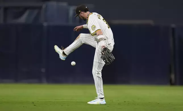 San Diego Padres centerfielder Jackson Merrill juggles the ball at the start of the sixth inning in Game 2 of an NL Wild Card Series baseball game against the Atlanta Braves Wednesday, Oct. 2, 2024, in San Diego. (AP Photo/Gregory Bull)