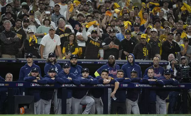 Members to the Atlanta Braves watch from the dugout during the ninth inning in Game 2 of an NL Wild Card Series baseball game against the San Diego Padres, Wednesday, Oct. 2, 2024, in San Diego. (AP Photo/Gregory Bull)