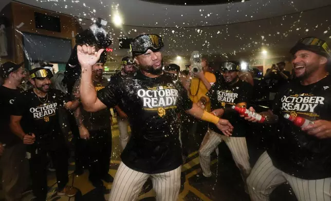 San Diego Padres players celebrate in the dugout after defeating the Atlanta Braves in Game 2 of an NL Wild Card Series baseball game Wednesday, Oct. 2, 2024, in San Diego. (AP Photo/Gregory Bull)