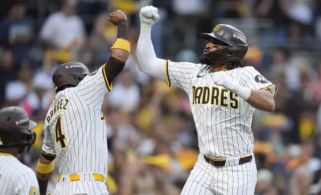 San Diego Padres' Fernando Tatis Jr., right, celebrates with Luis Arraez (4) after hitting a two-run home run during the first inning in Game 1 of an NL Wild Card Series baseball game against the Atlanta Braves, Tuesday, Oct. 1, 2024, in San Diego. (AP Photo/Gregory Bull)