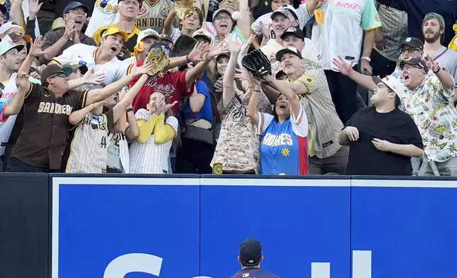 Atlanta Braves left fielder Ramón Laureano watches a home run ball from San Diego Padres' Kyle Higashioka go over the wall during the second inning in Game 2 of an NL Wild Card Series baseball game Wednesday, Oct. 2, 2024, in San Diego. (AP Photo/Gregory Bull)