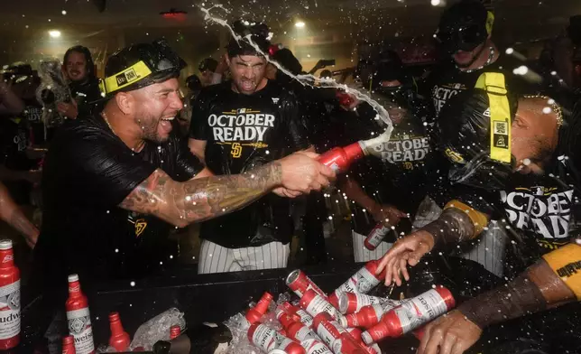 San Diego Padres players celebrate in the dugout after defeating the Atlanta Braves in Game 2 of an NL Wild Card Series baseball game Wednesday, Oct. 2, 2024, in San Diego. (AP Photo/Gregory Bull)