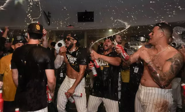 San Diego Padres players celebrate in the dugout after defeating the Atlanta Braves in Game 2 of an NL Wild Card Series baseball game Wednesday, Oct. 2, 2024, in San Diego. (AP Photo/Gregory Bull)