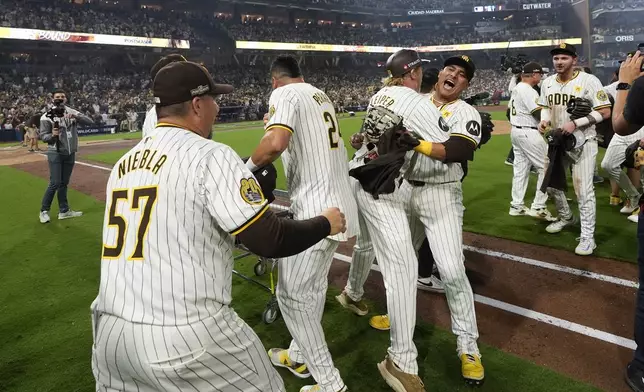 The San Diego Padres celebrate after a win over the Atlanta Braves in Game 2 of an NL Wild Card Series baseball game Wednesday, Oct. 2, 2024, in San Diego. (AP Photo/Gregory Bull)