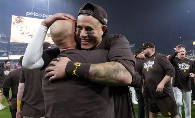 San Diego Padres' Manny Machado hugs bullpen catcher Gilberto Andrade after a win over the Atlanta Braves in Game 2 of an NL Wild Card Series baseball game Wednesday, Oct. 2, 2024, in San Diego. (AP Photo/Gregory Bull)