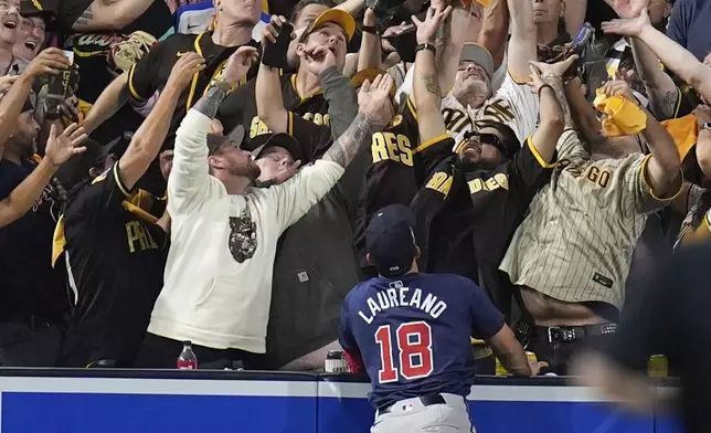 Atlanta Braves left fielder Ramón Laureano watches a home run from San Diego Padres' Kyle Higashioka go over the wall during the eighth inning in Game 1 of an NL Wild Card Series baseball game Tuesday, Oct. 1, 2024, in San Diego. (AP Photo/Gregory Bull)