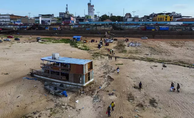 A boat is grounded in the Negro River at the port in Manaus, Amazonas state, Brazil, Friday, Oct. 4, 2024, amid severe drought. (AP Photo/Edmar Barros)