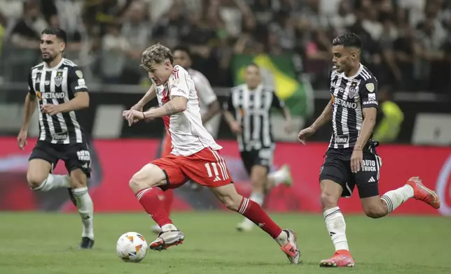 Facundo Colidio of Argentina's River Plate carries the ball followed by Fausto Vera of Brazil's Atletico Mineiro, right, during a Copa Libertadores semifinal first leg soccer match at MRV arena in Belo Horizonte, Brazil, Tuesday, Oct. 22, 2024. (AP Photo/Thomas Santos)