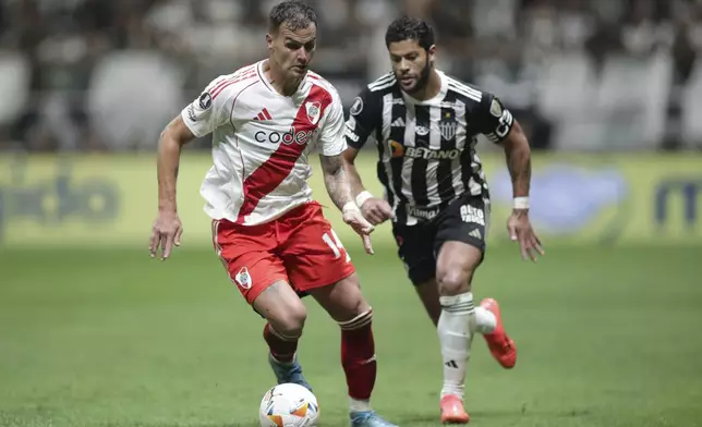 Leandro Gonzalez Pirez of Argentina's River Plate, left, is challenged by Hulk of Brazil's Atletico Mineiro during a Copa Libertadores semifinal first leg soccer match at MRV arena in Belo Horizonte, Brazil, Tuesday, Oct. 22, 2024. (AP Photo/Thomas Santos)