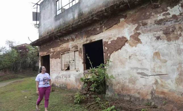 Monica dos Santos, 39, walks past her former village's bar that was destroyed when a dam broke in Bento Rodrigues, Minas Gerais state, Brazil, Oct. 19, 2024. Victims of Brazil’s worst environmental disaster, on Nov. 5, 2015, took their case for compensation to a UK court on Monday, Oct. 21, 2024, almost nine years after tons of toxic mining waste poured into a major waterway, killing 19 people and devastating local communities. (AP Photo/Eleonore Hughes)