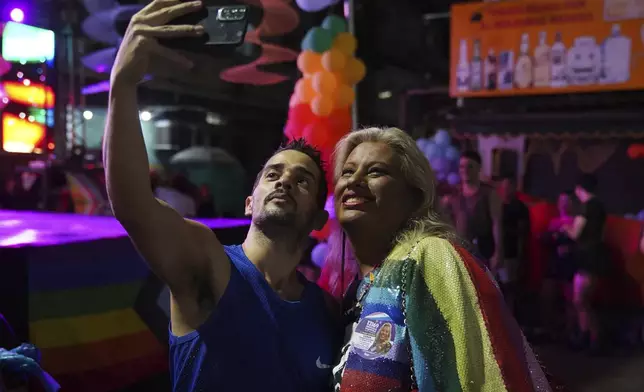 Indianarae Siqueira, a transgender woman running for city council, poses for a selfie with a supporter at an LGBTQIA+ pride parade in the Mare neighborhood of Rio de Janeiro, Sunday, Sept. 29, 2024. (AP Photo/Hannah-Kathryn Valles)