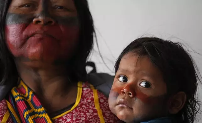 An Indigenous woman holds her son during a protest against a proposed constitutional amendment that threatens some Indigenous land rights, in Brasilia, Brazil, Wednesday, Oct. 30, 2024. (AP Photo/Eraldo Peres)