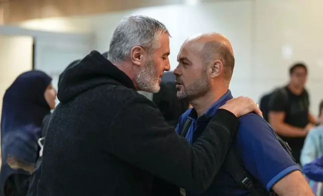 Lebanese citizen Ali Zeineddine, left, greets his brother Hussein arriving from Lebanon, after an Israeli air strike killed various members of their family, at Sao Paulo International airport, Thursday, Oct. 3, 2024. (AP Photo/Andre Penner)