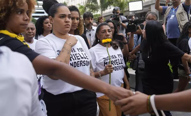 Mother of slain councilwoman Marielle Franco, Marinete Silva, right center, and Luyara Santos, left center, daughter of slain councilwoman Marielle Franco, accompanied by other family members, arrive to follow the trial of former city councilwoman Marielle Franco's alleged killers, in Rio de Janeiro, Brazil, Wednesday, Oct. 30, 2024. (AP Photo/Silvia Izquierdo)