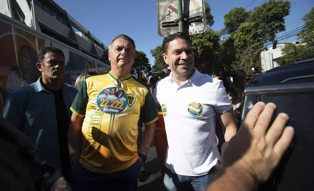 Former President Jair Bolsonaro, center, supports Rio de Janeiro mayoral candidate Alexandre Ramagem, right, after voting in the municipal elections, in Rio de Janeiro, Sunday, Oct. 6, 2024. (AP Photo/Bruna Prado)