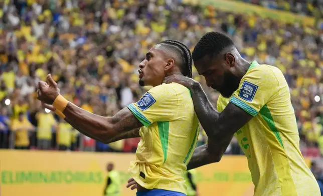 Brazil's Raphinha, left, celebrates after scoring his side's second goal from the penalty spot against Peru during a qualifying soccer match for the FIFA World Cup 2026 at Mane Garrincha Stadium in Brasilia, Brazil, Tuesday, Oct. 15, 2024. (AP Photo/Eraldo Peres)