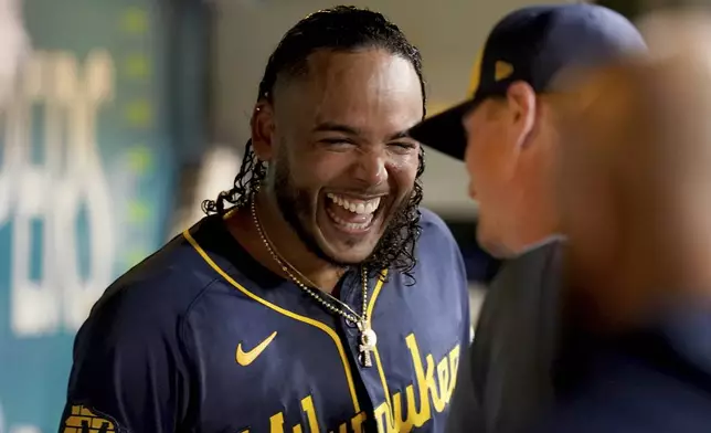 Milwaukee Brewers starter Freddy Peralta celebrates in the dugout after getting his 200th strikeout of the season during the sixth inning of a baseball game against the Pittsburgh Pirates, Wednesday, Sept. 25, 2024, in Pittsburgh. (AP Photo/Matt Freed)