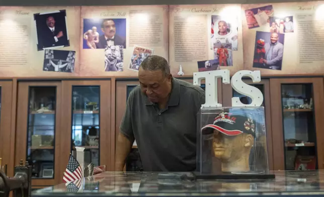 Vernon Banks, a volunteer at the Turner Station History Center, looks at photos in the community museum, Friday, Aug. 16, 2024, in Turner Station, Md. (AP Photo/Stephanie Scarbrough)