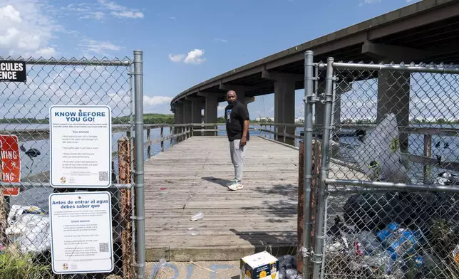 Turner Station resident Marquis Neal looks toward garbage that has piled up on a pier at Fleming Park in Turner Station, Md., Tuesday, Aug. 13, 2024. (AP Photo/Stephanie Scarbrough)